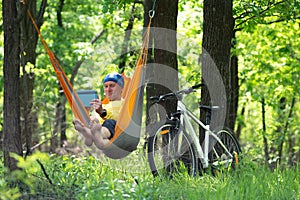 Man relaxes and uses tablet pc in a hammock