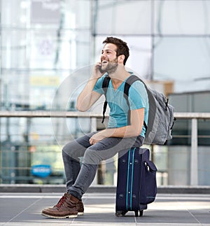 Man relaxing at airport and talking on mobile phone