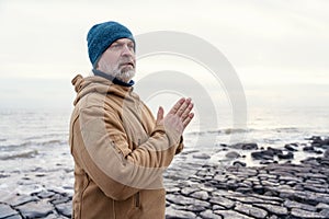 Man relaxing alone on the seaside on cold winter day. Travel Lifestyle concept