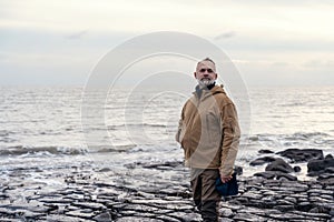 Man relaxing alone on the seaside on cold winter day. Travel Lifestyle concept