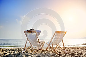 Muž relaxačné na pláž na paluba stoličky 