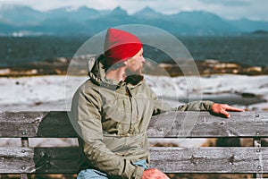 Man relaxing on bench enjoying sea and mountains landscape Norway vacations Traveling Lifestyle concept. Traveler sitting alone we