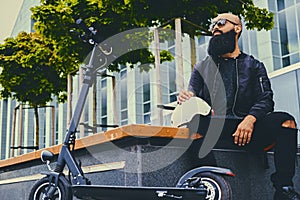 A man relaxing on a bench after riding by electric scooter.