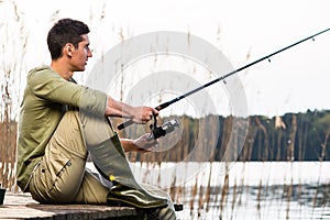Man relaxing fishing or angling at lake