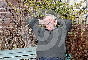 Man relaxing with hands behind head.