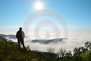 Man relaxing on hiking trip in beautiful foggy mountains..