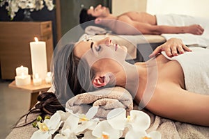 Man relaxing with his partner on massage beds at wellness center