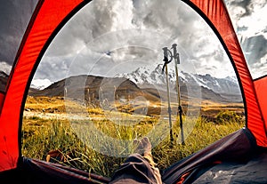 Man relaxing in his tent in the mountains