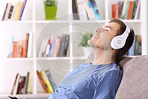 Man relaxing at home listening to music