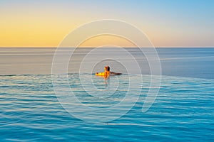 Man relaxing In Infinity Edge Swimming Pool Water