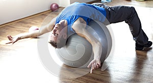 Man relaxing on large stability ball