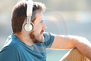Man relaxing and looking listening to music outdoors