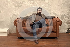 Man relaxing on luxurious leather couch, classic style concept