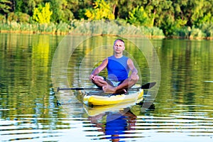 Man is relaxing and meditating on a SUP board
