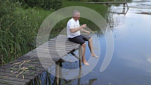 Man relaxing near pond on the footboard