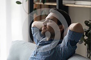 Man relaxing on sofa daydreams enjoy weekend at modern home