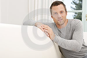 Man relaxing on sofa at home.