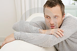 Man relaxing on sofa at home.