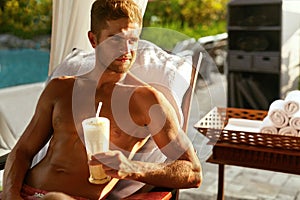 Man Relaxing At Spa With Cocktail Drink On Summer Vacations