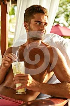 Man Relaxing At Spa With Cocktail Drink On Summer Vacations