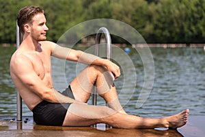 Man relaxing in the sun at public swimming pool