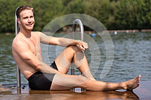Man relaxing in the sun at public swimming pool