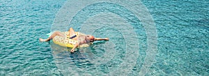 Man relaxing when swims on inflatable pineapple pool ring in crystal clear sea water. Careless vacation concept image