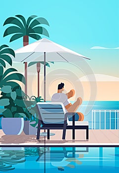 man relaxing at tropical luxury resort hotel beach swimming pool and poolside seating area summer vacation concept