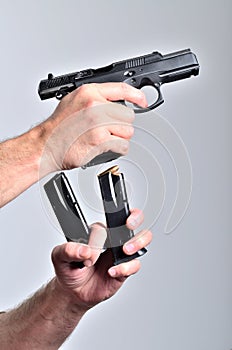 Man reloading pistol gun after shooting isolated vertical photo