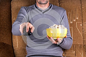 Man with remote control and popcorn