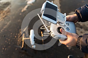 Man with remote control prepare white drone digital camera for start flying in winter