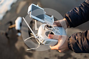 Man with remote control prepare white drone digital camera for start flying in winter