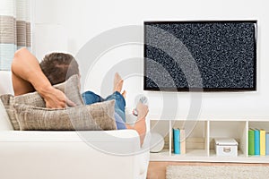 Man With Remote Control Watching Television