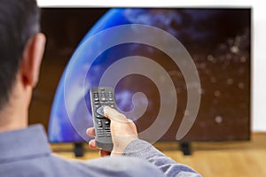 Man with remote control watching tv