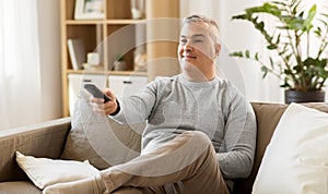 Man with remote control watching tv at home