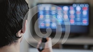 Man with remote control watching TV at home