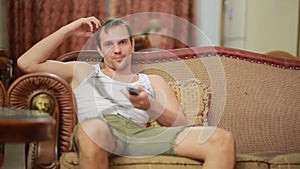 Man with remote control watching tv at home