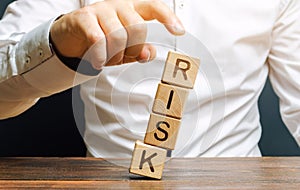 Man removes blocks with the word Risk. The concept of reducing possible risks. Insurance, stability support. Legal protection of