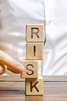 Man removes blocks with the word Risk. The concept of reducing possible risks. Insurance, stability support. Legal protection of