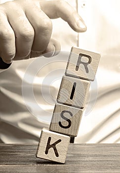 Man removes blocks with the word Risk. The concept of reducing possible risks. Insurance, stability support. Legal protection of