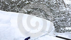 Man removes snow from canopy with roof rake