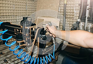 Man is removing dust from the computer numerical control machine for wooden tools. CNC equipment for maintenance control and