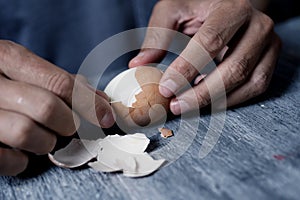 Man removing the eggshell of a boiled egg