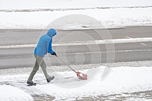 Man Removing Snow in His Driveway with a Shovel 4