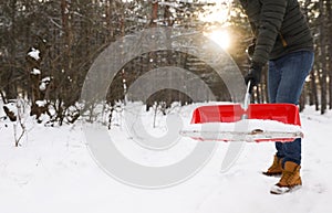 Man removing snow with shovel outdoors on winter day, closeup