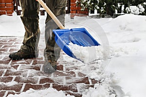 Man removing snow from the sidewalk after snowstorm