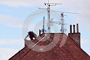 Man renovating an old chimney on the rooftop