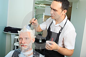 Man repaint the hair in a beauty salon