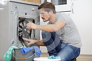 Man repair and fixing washing machine leaky