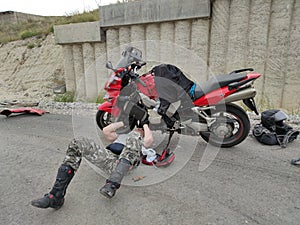 Man repair motorbike on road